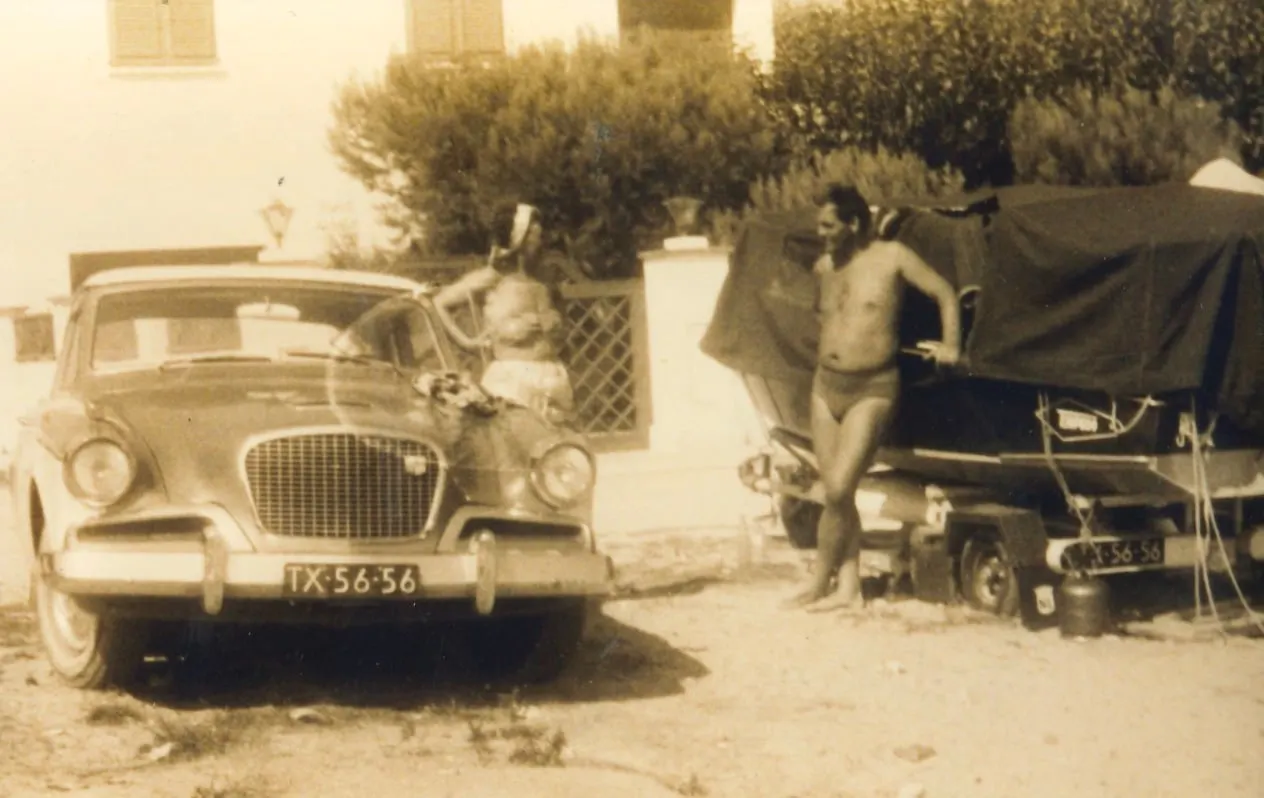 Toos y Gerrit van der Valk junto a un coche con remolque para la barca, delante del Hotel Barcarola
